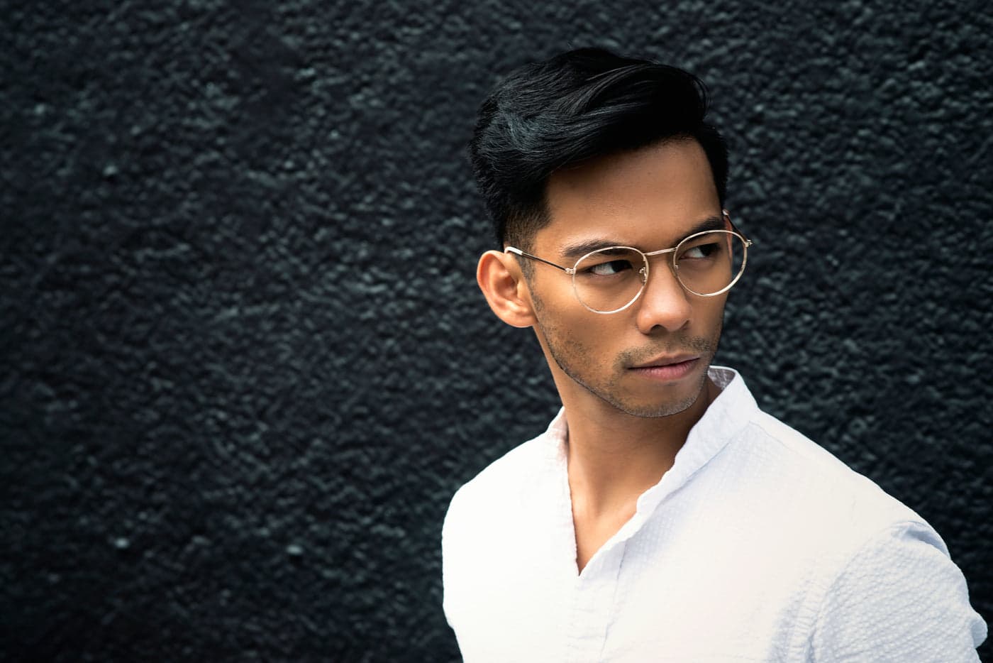 A man wearing fine round metal glasses