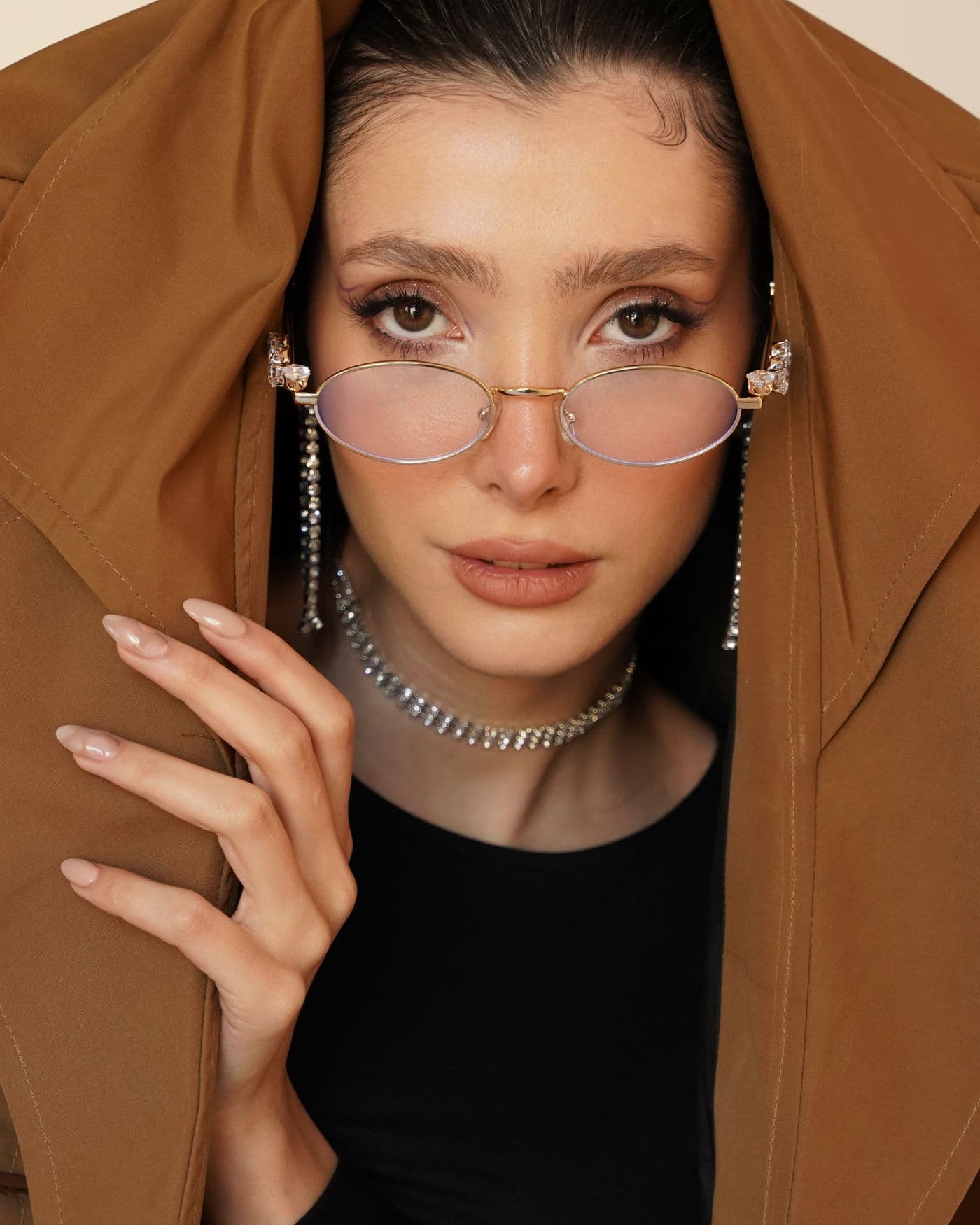 A woman wearing gold glasses with a chain