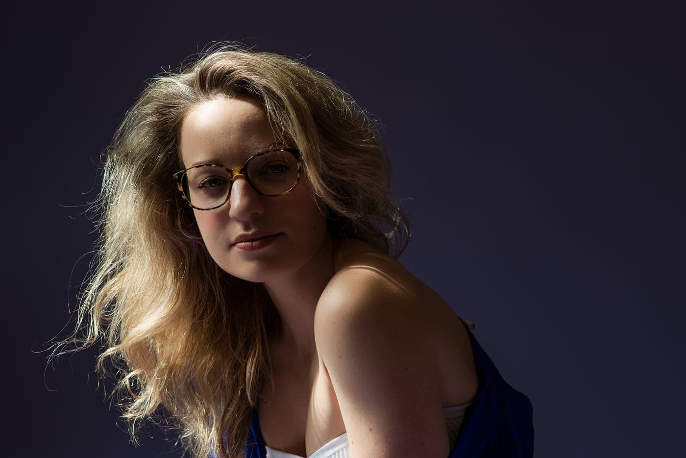A woman wearing round tortoiseshell glasses